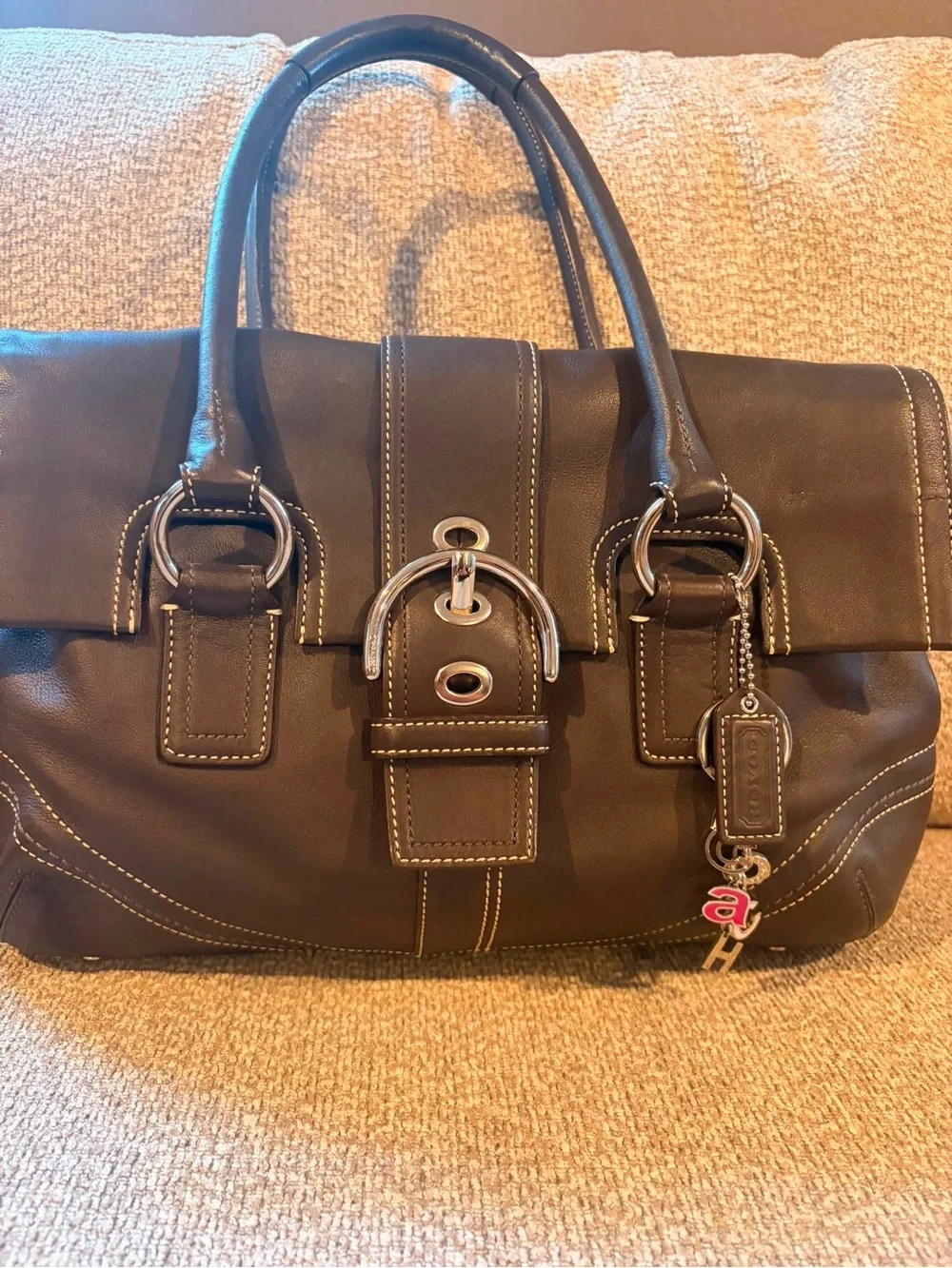 Coach Dark Brown Leather Buckle Satchel with Contrast Stitching.